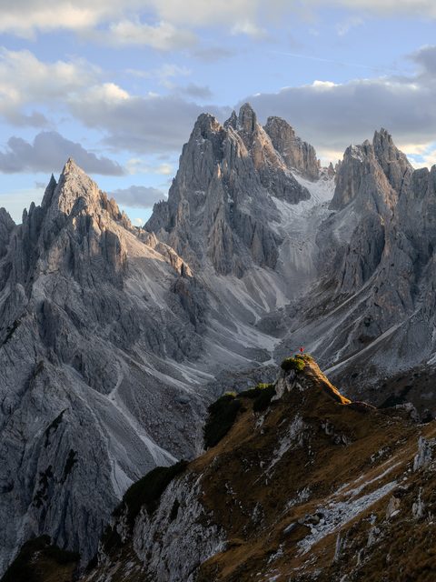 A jagged limestone peak catching golden light, framed by rows of receding mountain ridges.